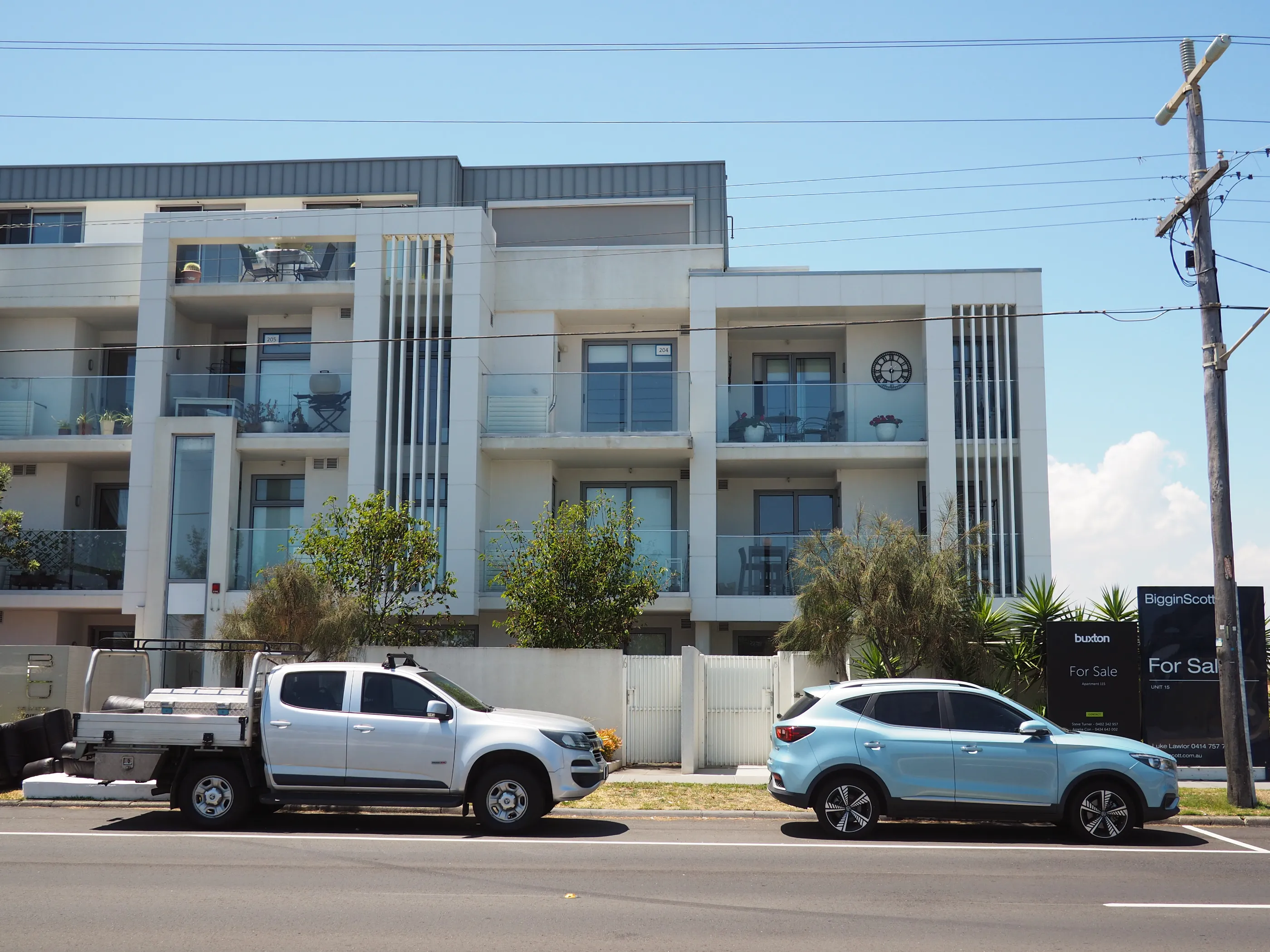 A boring multi-tenant building with white cladding and big windows.