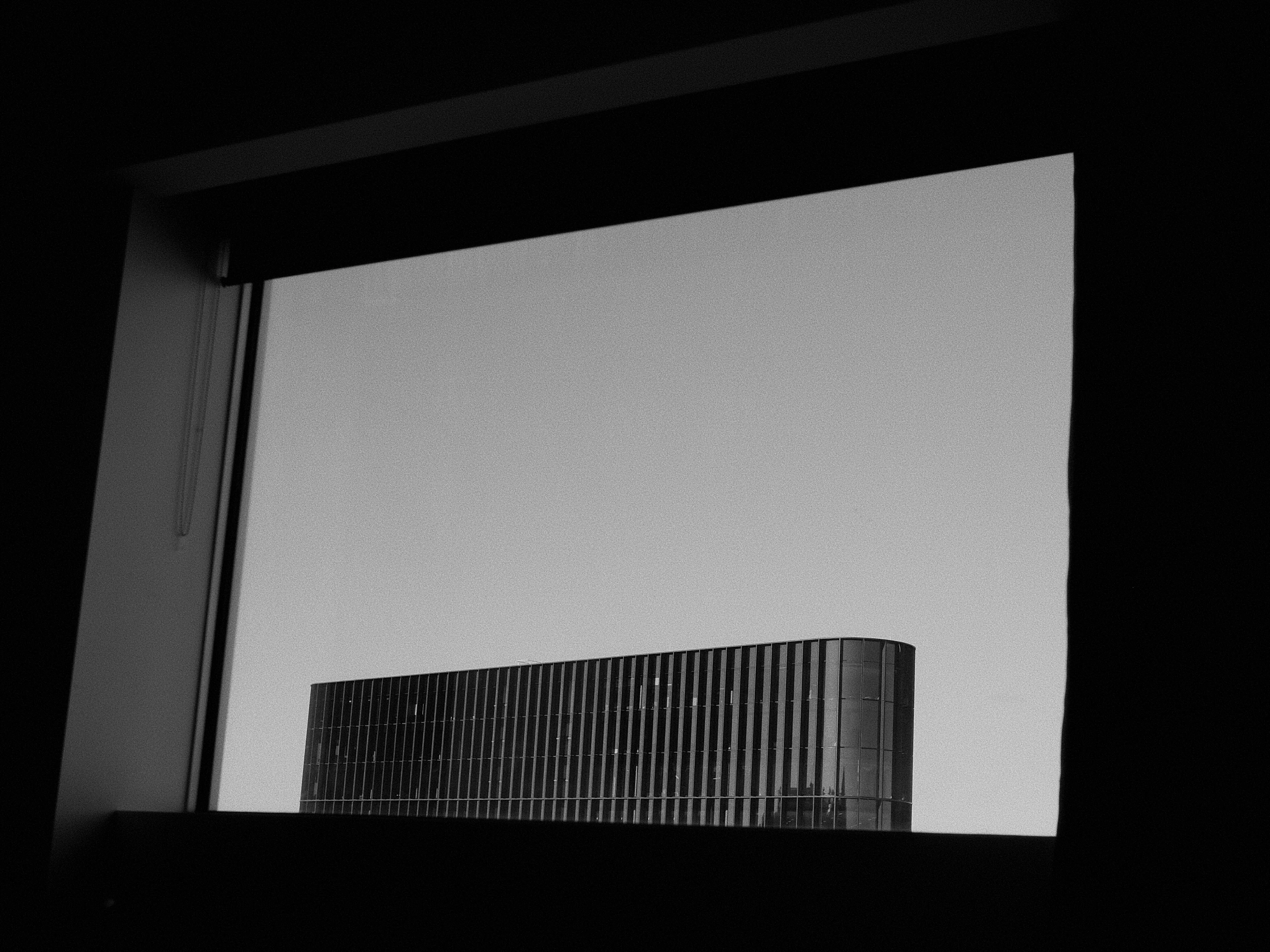 View through a large window over the top of a building opposite.